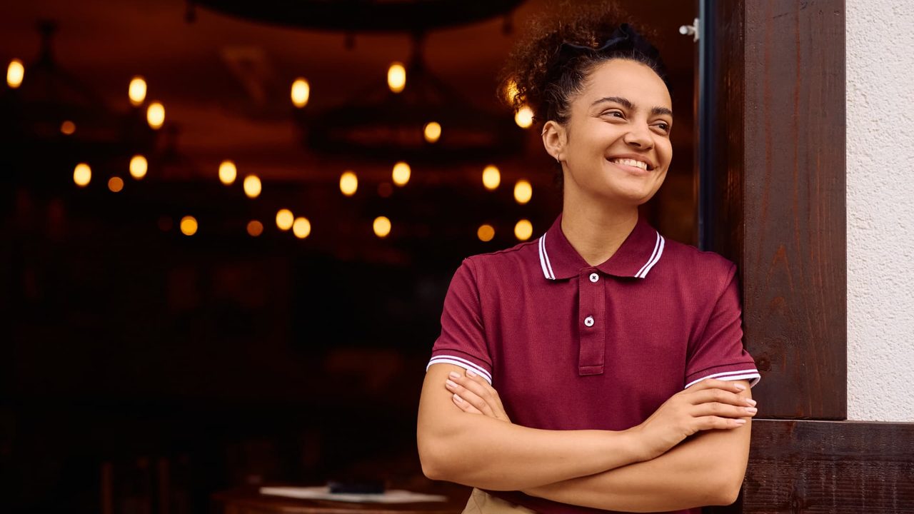 Restaurant operator standing at the entrance of a busy venue.